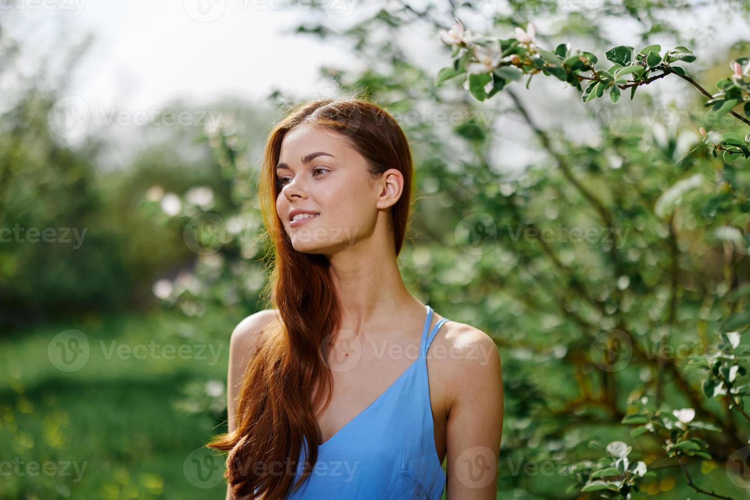 mulher sorrir com dentes felicidade dentro natureza dentro a verão perto uma verde árvore dentro a jardim do a parque, a conceito do mulheres saúde e beleza com natureza pôr do sol foto