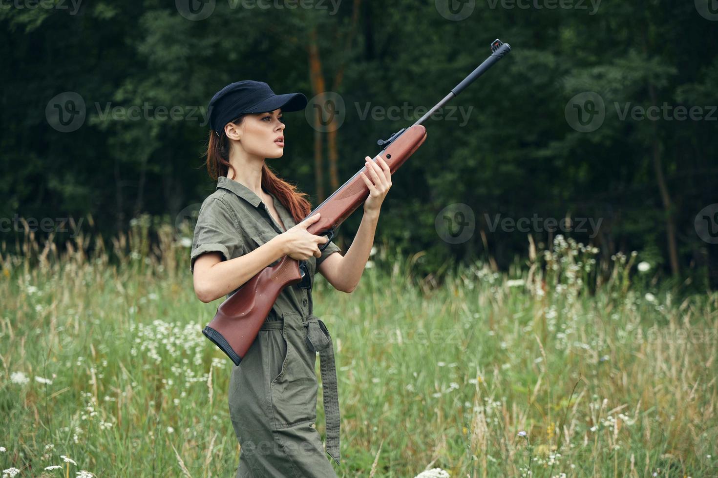 mulher em ao ar livre segurando uma arma dentro dele mãos verde macacão Preto boné estilo de vida fresco ar foto