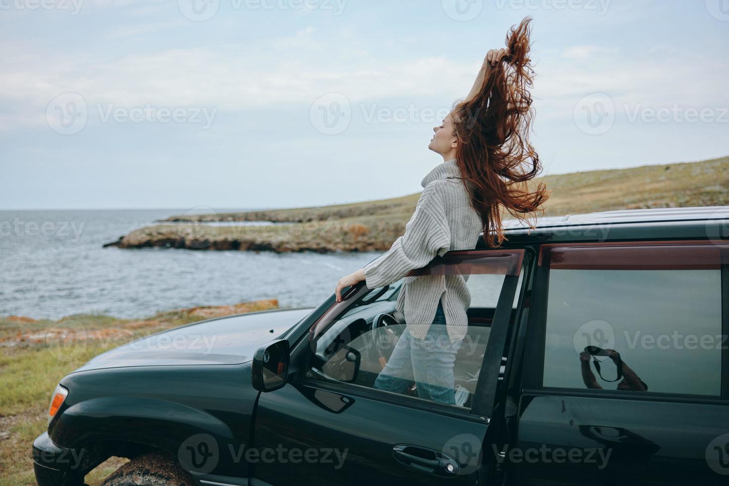 mulher com vermelho cabelo dentro uma suéter perto a carro natureza fêmea relaxante foto