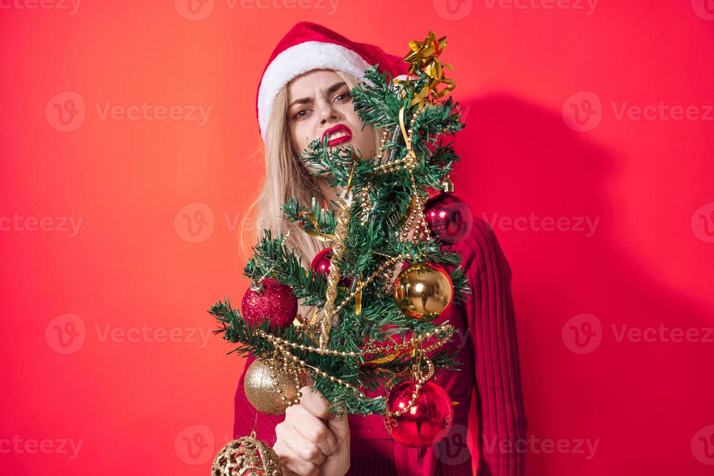 bonita mulher segurando Natal árvore decoração feriado Diversão vermelho fundo foto