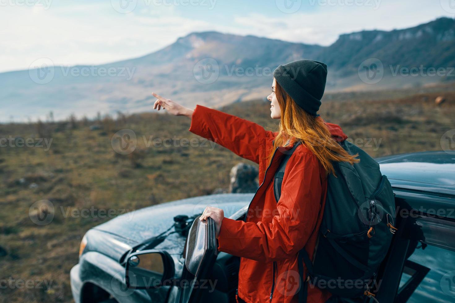 mulher caminhante dentro a montanhas em natureza perto a carro com uma mochila em a costas foto