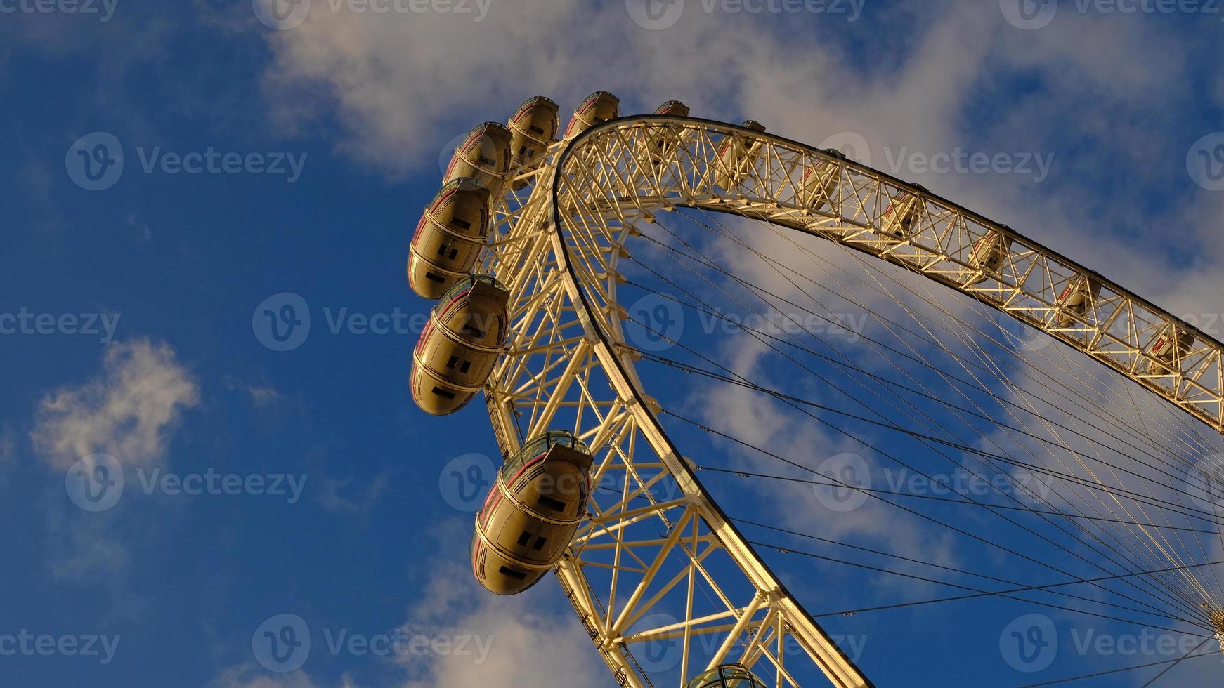 ferris roda dentro a diversão parque em fundo do azul céu com nuvens. baixo ângulo Visão do uma grande ferris roda. foto