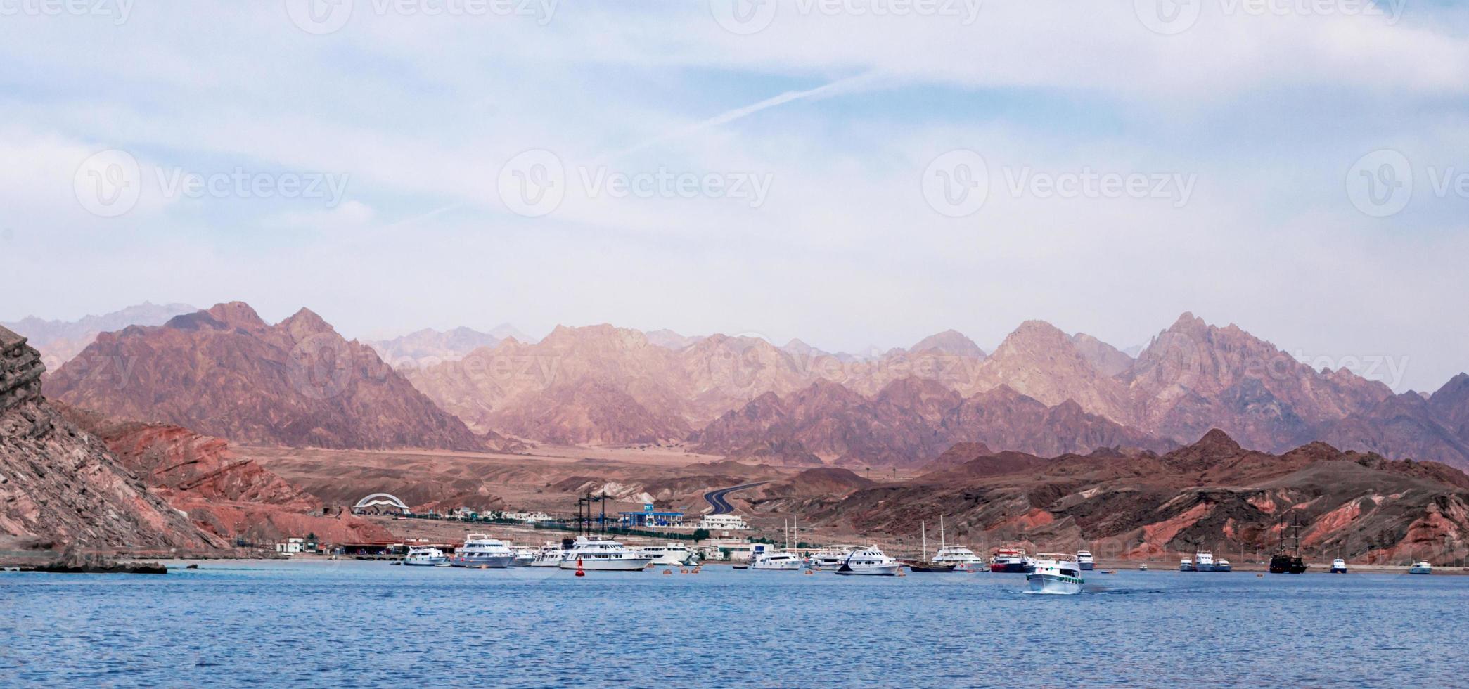 barcos de cruzeiro perto de uma costa rochosa foto