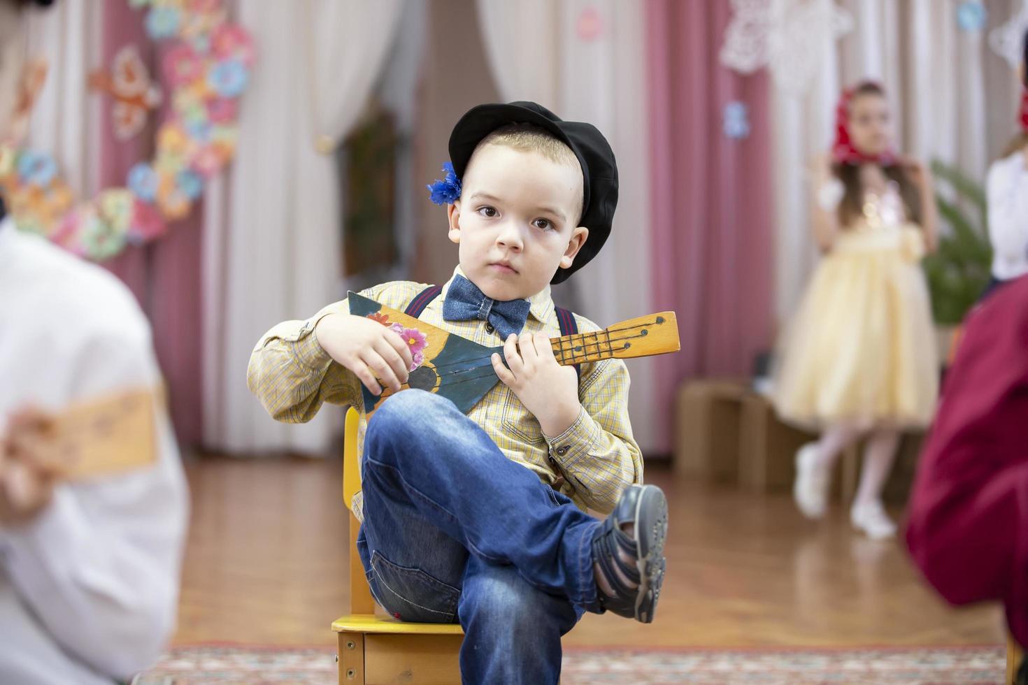 russo Garoto com uma balalaica. engraçado pré-escolar com russo folk musical instrumento. foto