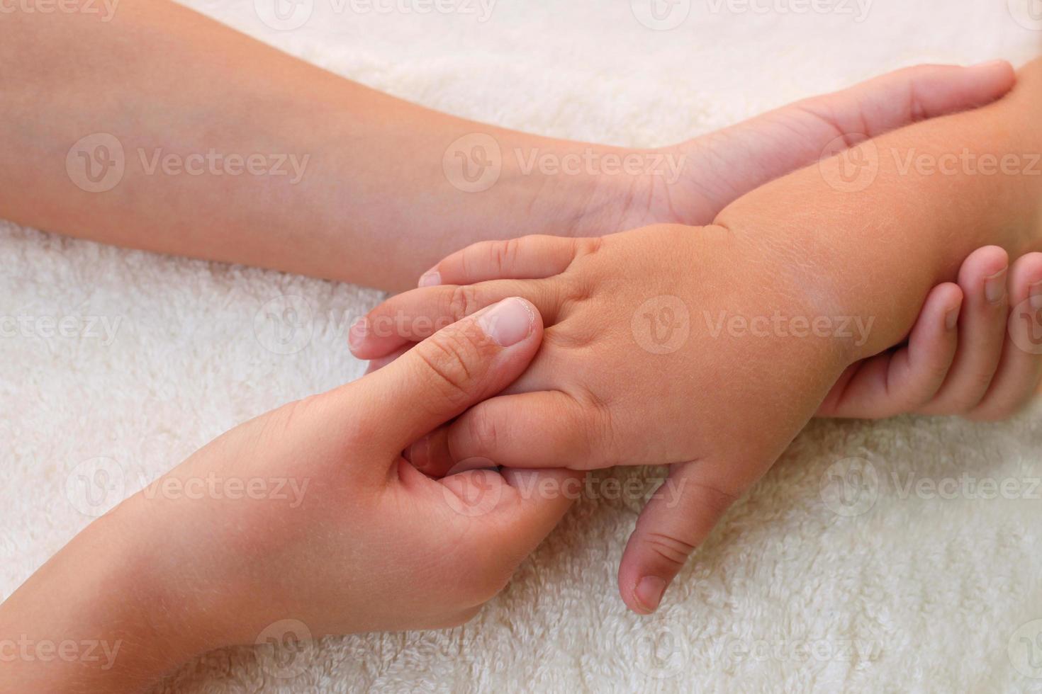 massagista fazendo massagem dedos pequeno bebê. foto