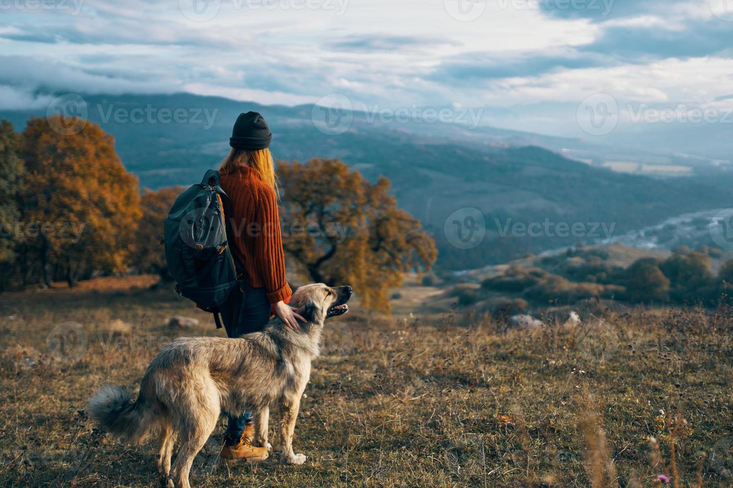 mulheres caminhantes Próximo para cachorro andar montanhas outono floresta foto