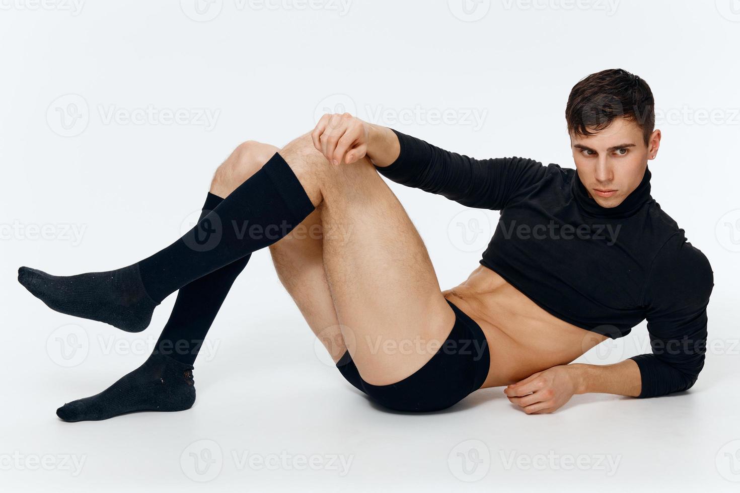 sexy cara dentro elegante roupas dentro meias e calção em uma luz fundo modelo foto