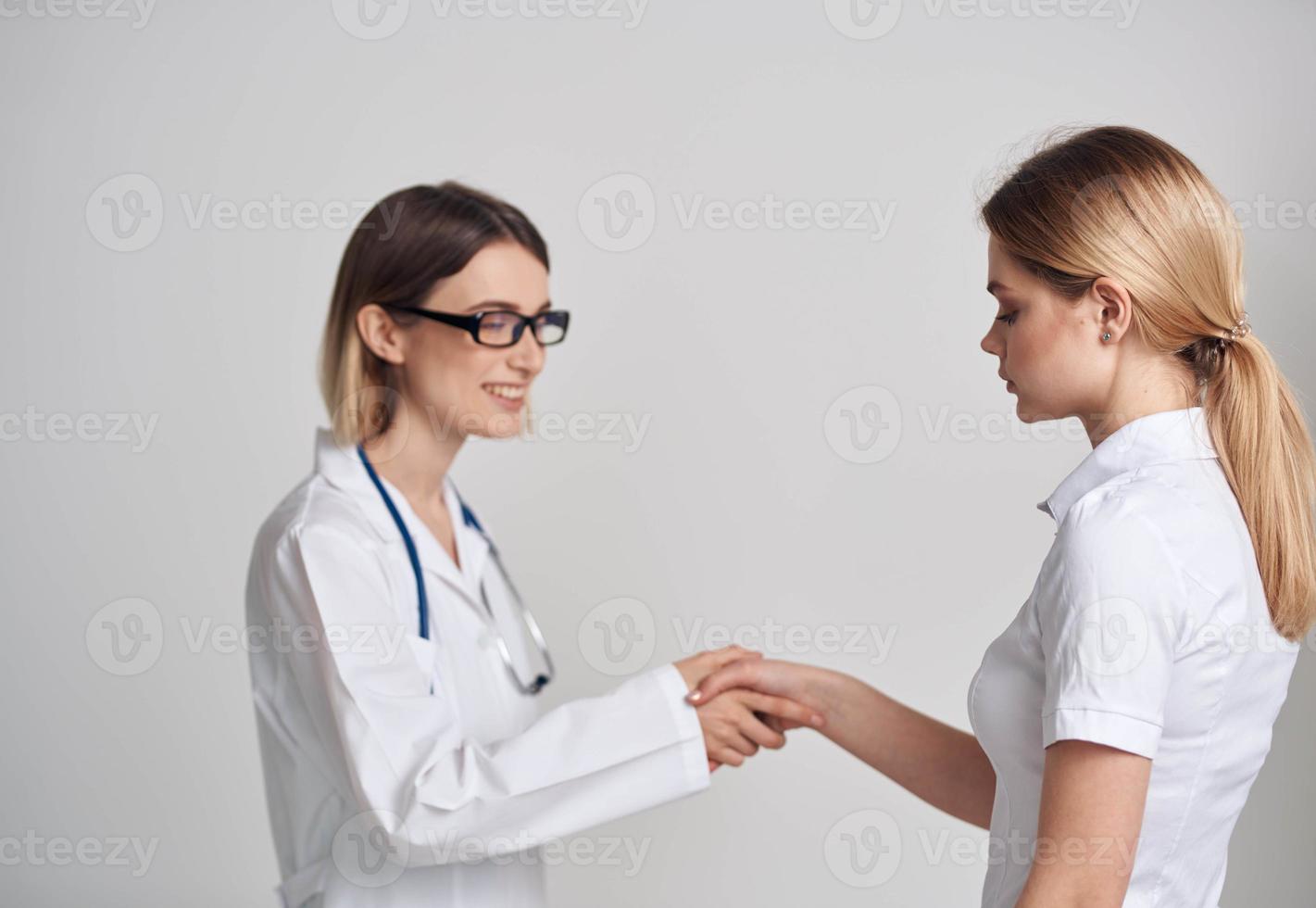 profissional médico mulher e paciente mexe mãos em uma luz fundo foto