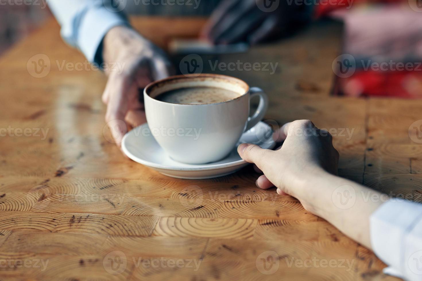 a chefe de cozinha serve a cliente uma copo do café com uma pires em a mesa e uma restaurante beber foto