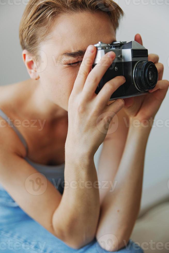 mulher fotógrafo tiroteio dentro estúdio em velho filme Câmera às casa em sofá retrato, branco fundo, livre cópia de espaço, freelance fotógrafo foto