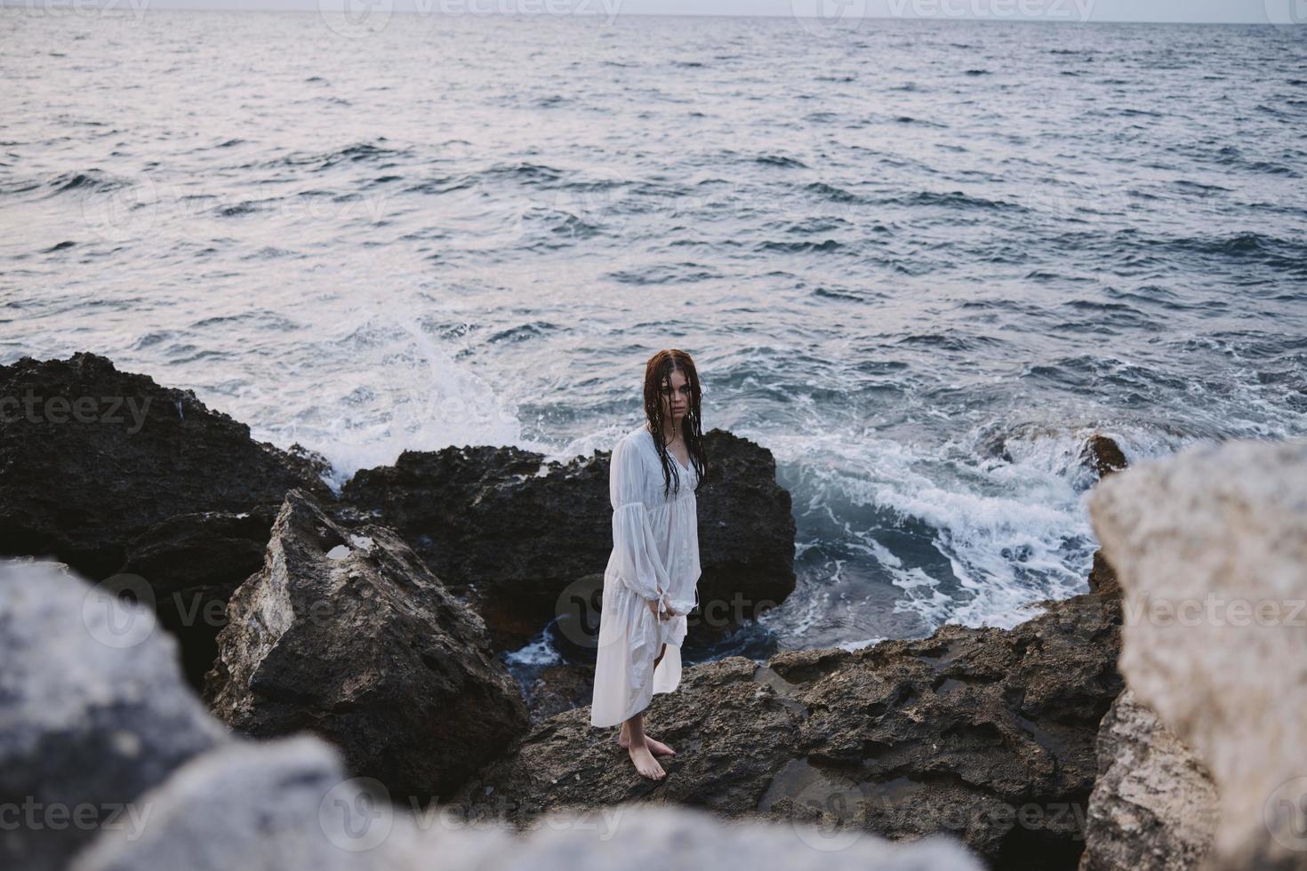 mulher viajante anda em vulcânico Rocha formações em a ilha relaxar foto