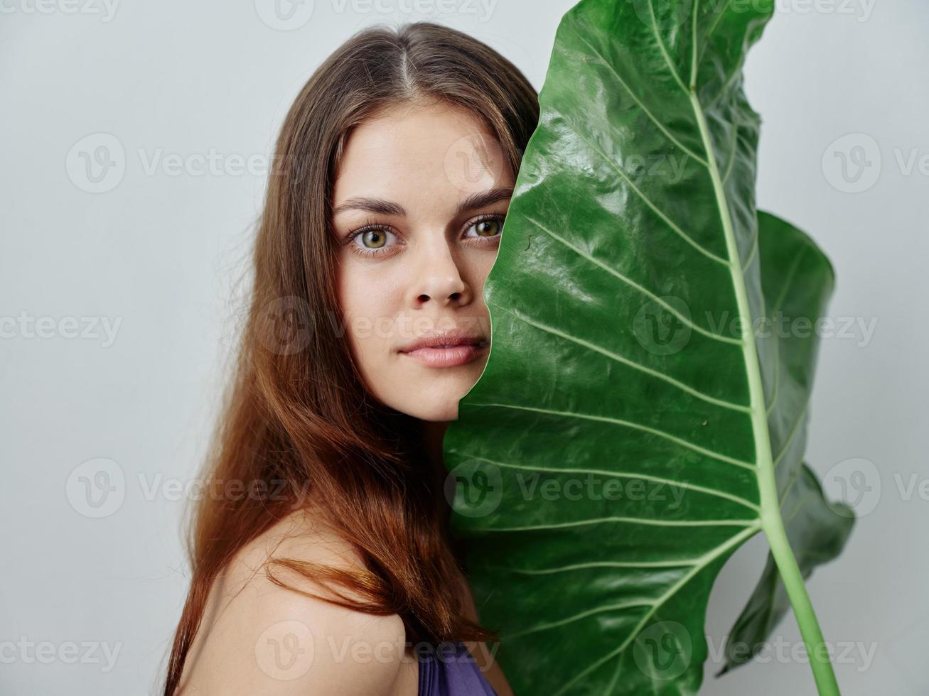 bonita ruivo mulher com verde Palma folha dentro roupa de banho foto