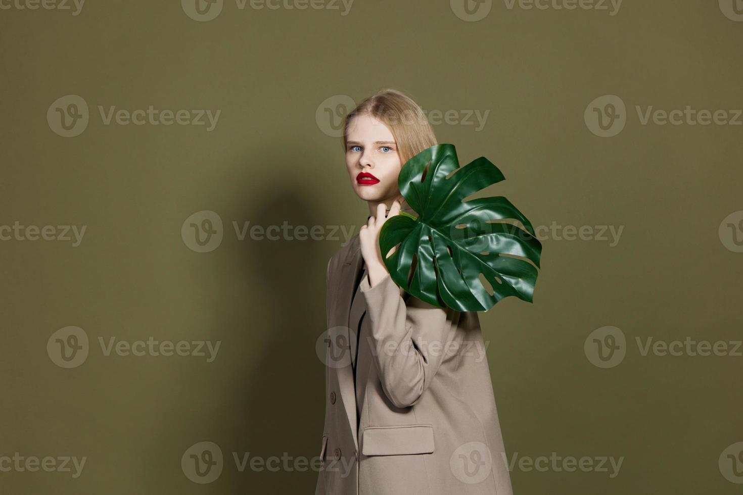 bonita mulher dentro casaco vermelho lábios moda Palma folha estúdio modelo inalterado foto