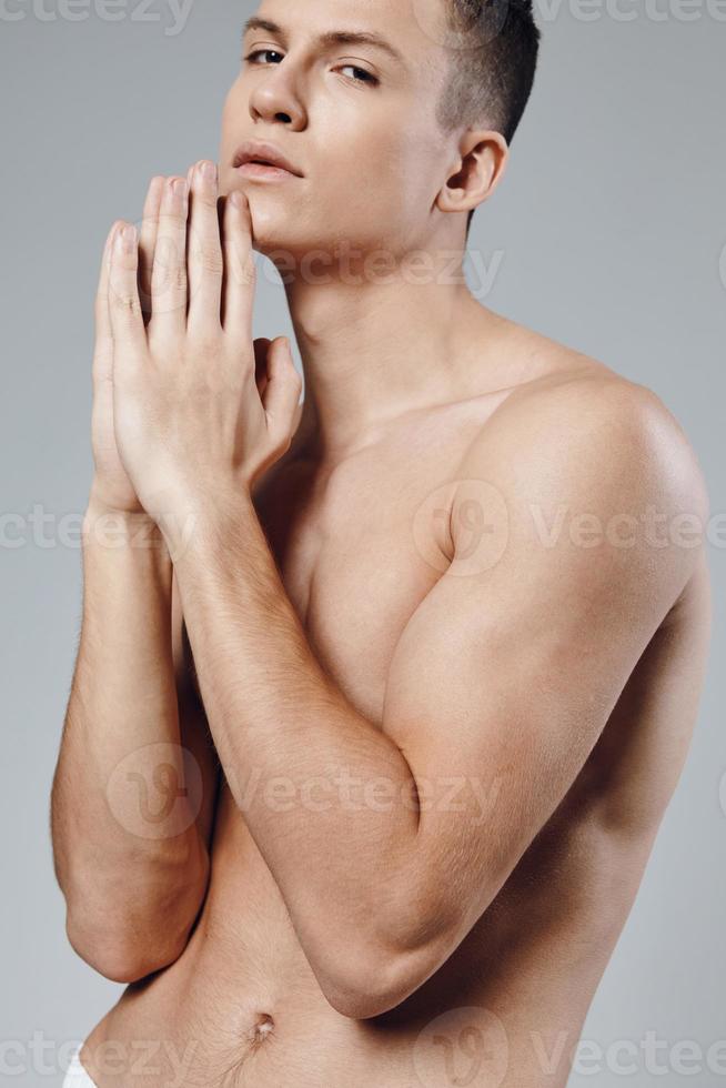 desportivo homem com bombeado acima músculos do dele mãos conectado dele dedos perto a face foto
