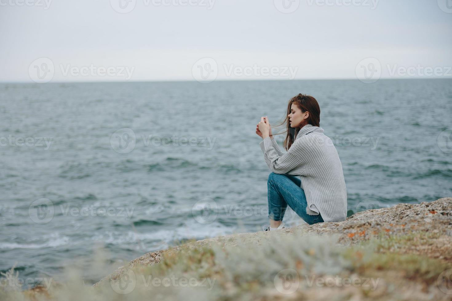 bonita mulher blusas nublado mar admirando natureza relaxamento conceito foto