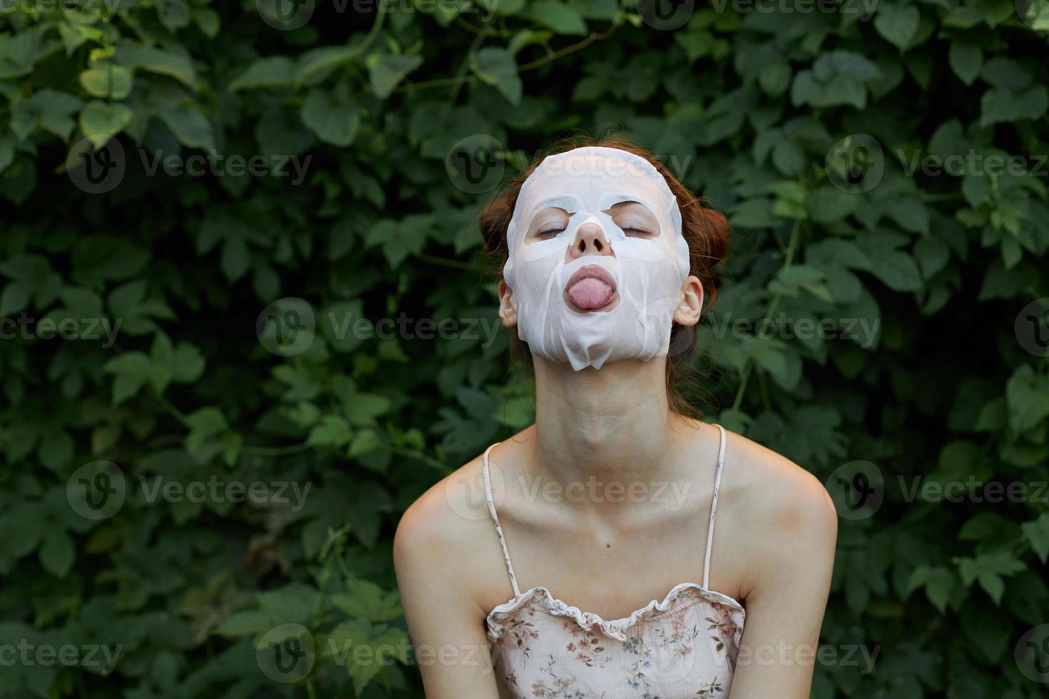 retrato do uma menina anti-envelhecimento mascarar língua Fora emoção modelo cosmetologia arbustos dentro a fundo foto