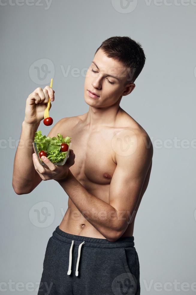 Atlético homem com uma bombeado corpo prato salada legumes saudável Comida estilo de vida foto