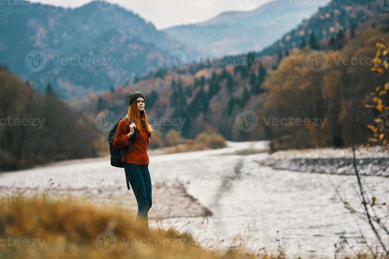 mulher com mochila caminhada de a rio dentro a montanhas panorama foto