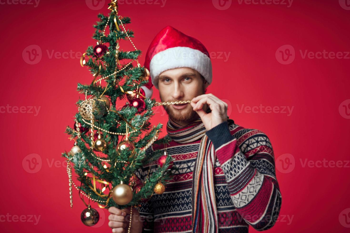 homem com Natal árvore brinquedos feriado decoração vermelho fundo foto