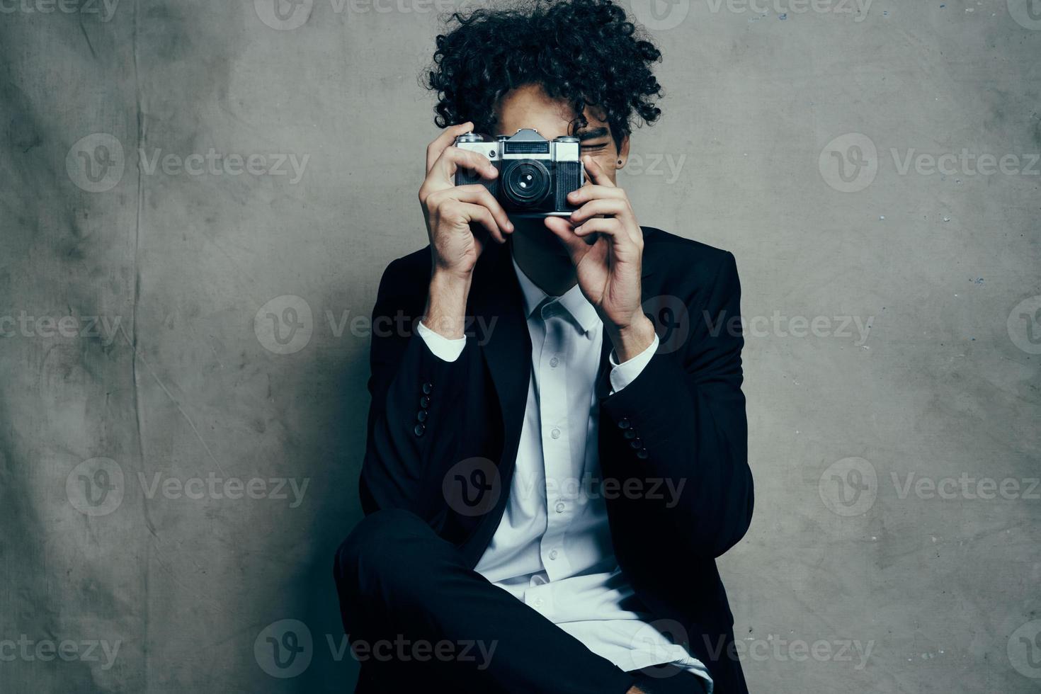 bonito homem dentro estúdio com Câmera tecido fundo clássico terno modelo foto