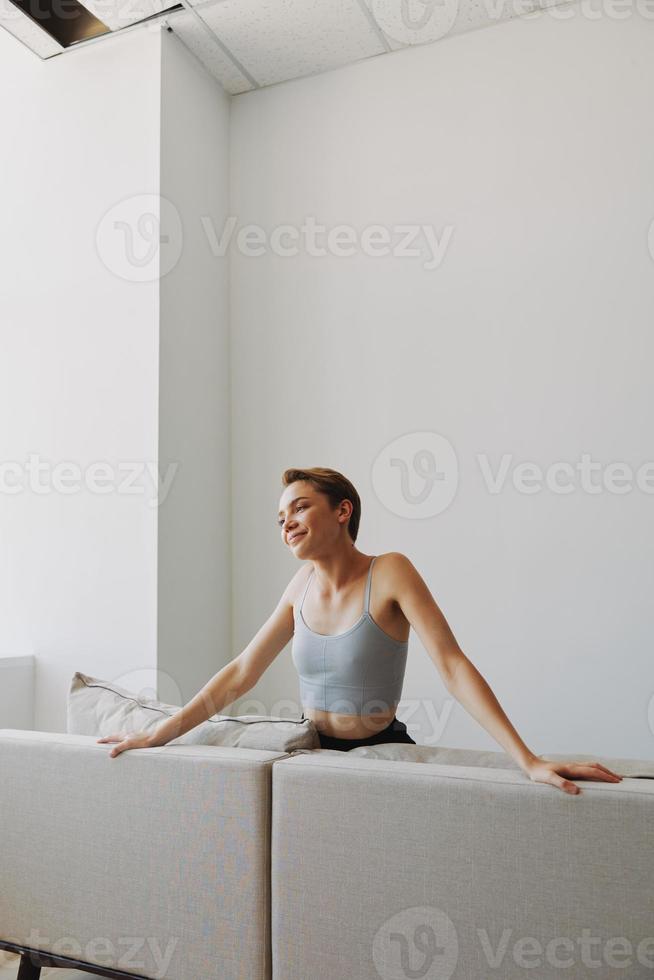 feliz mulher sorrir deitado às casa em a sofá relaxante em uma final de semana às casa com uma curto corte de cabelo cabelo sem filtros em uma branco fundo, livre cópia de espaço foto