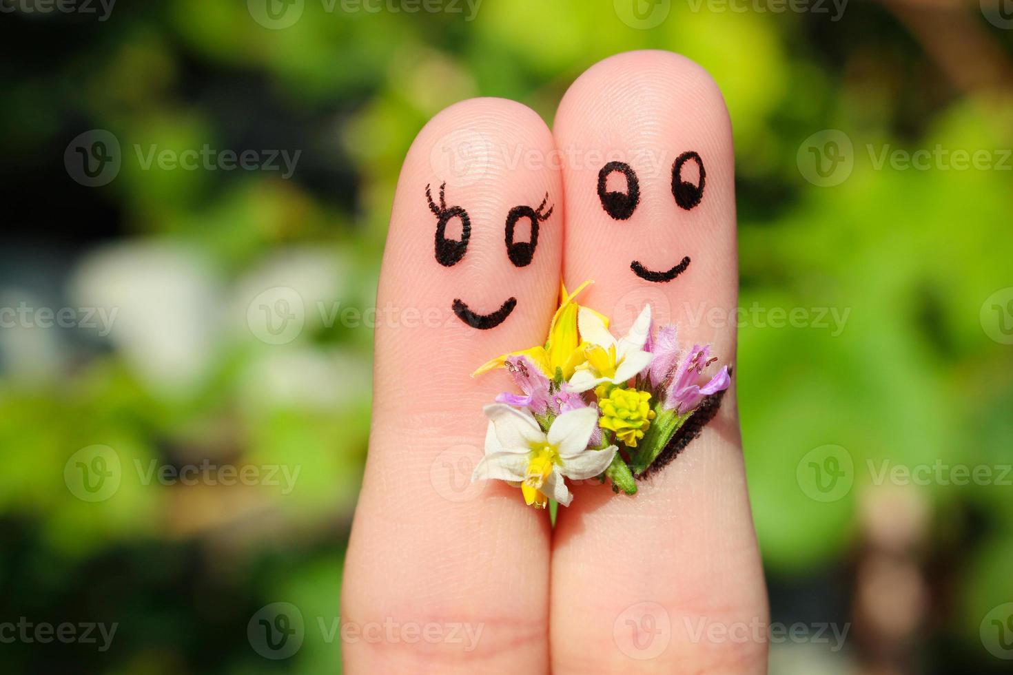 dedo arte do uma feliz casal. homem é dando flores para uma mulher. foto