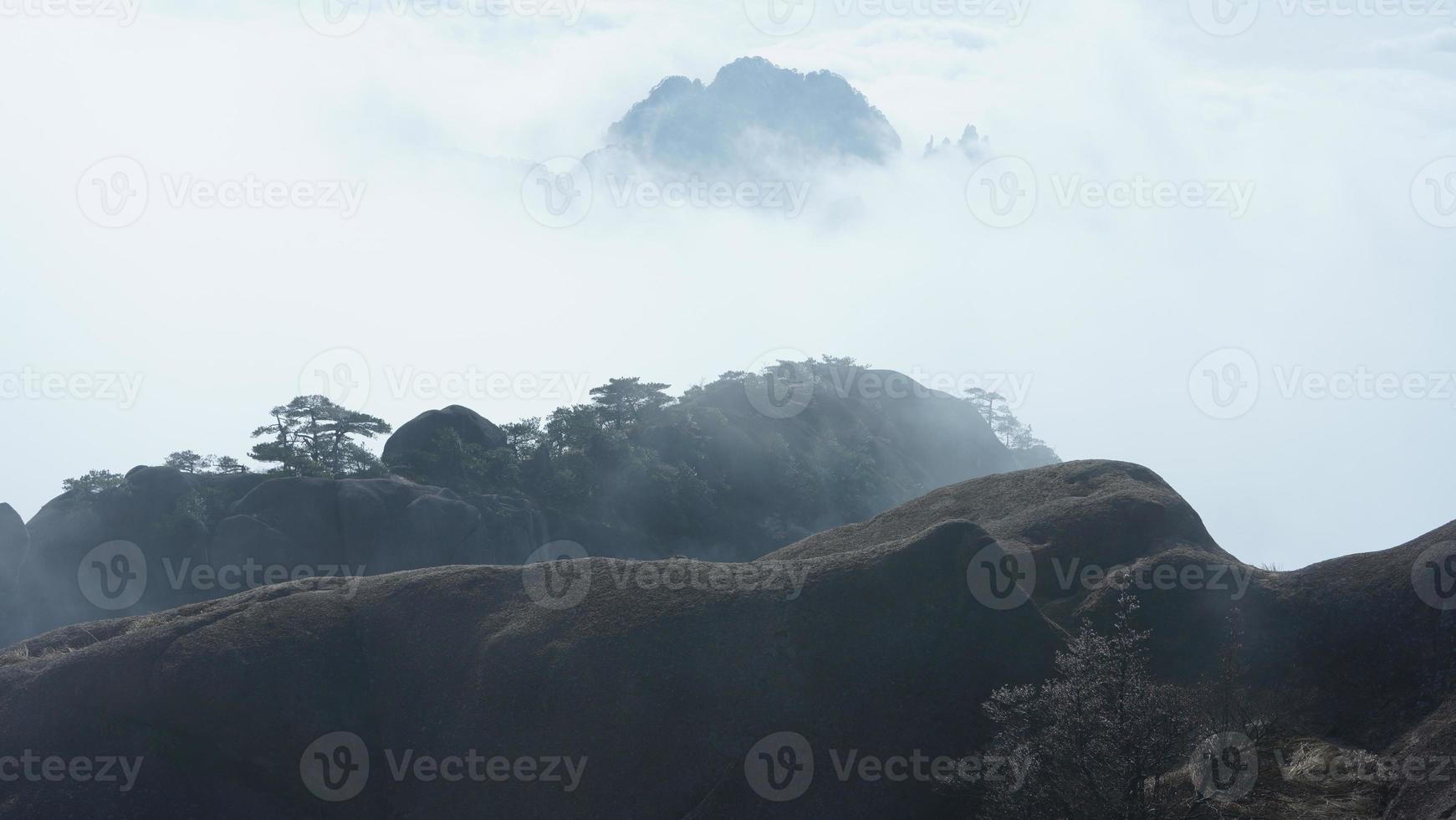 as belas paisagens das montanhas com a floresta verde e o penhasco rochoso em erupção como pano de fundo na zona rural da china foto