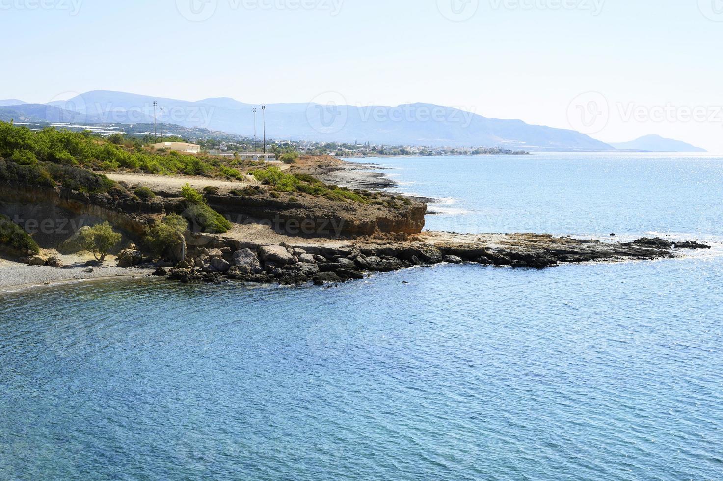 bela lagoa azul com água do mar cristalina e uma praia de seixos e pedras foto