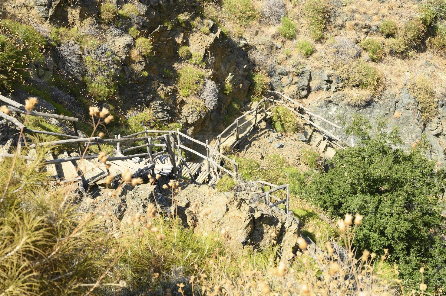 escada de madeira caseira antiga que percorre rochas em um desfiladeiro na montanha foto