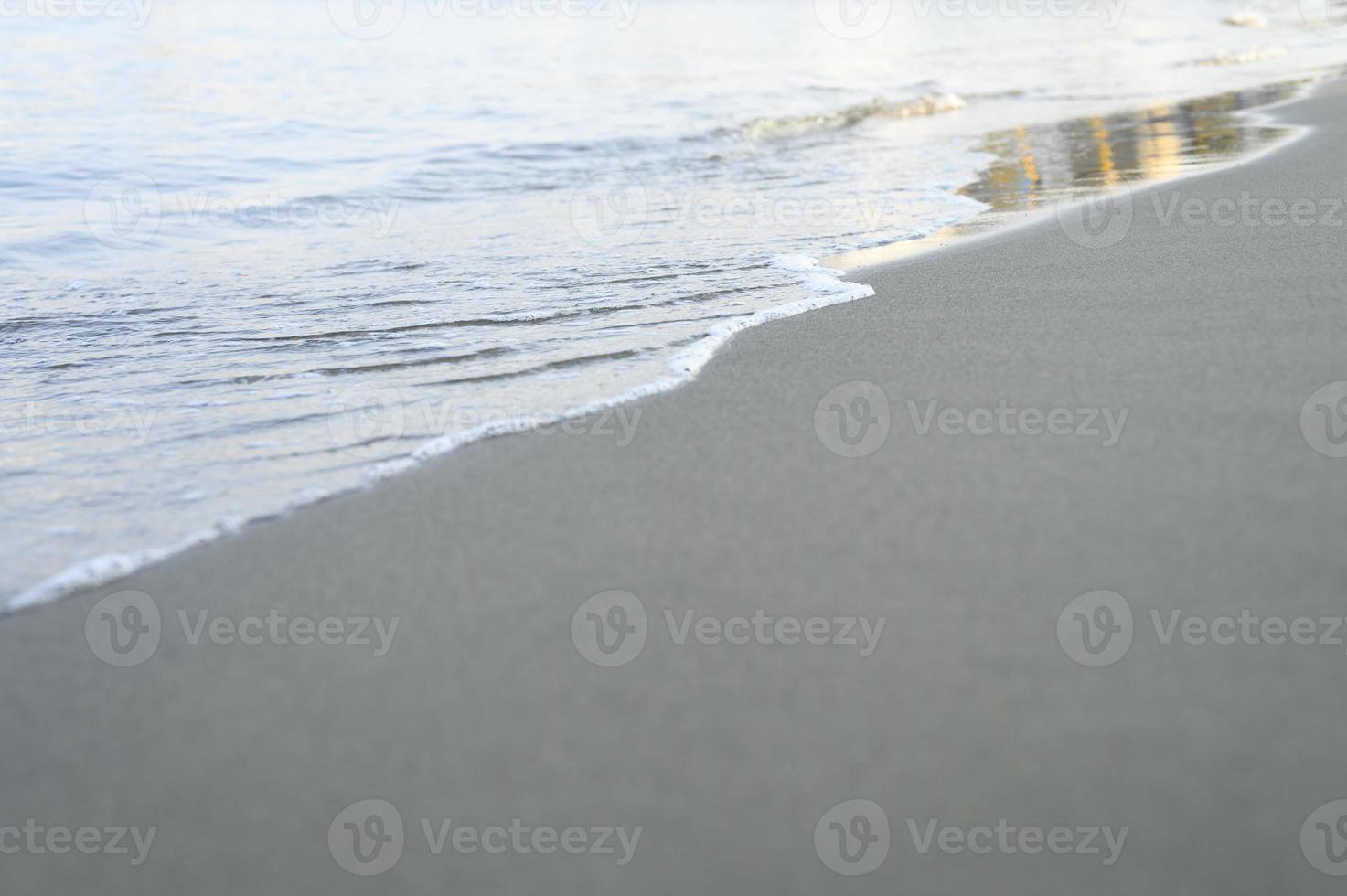 onda turva do mar na praia de areia à noite foto