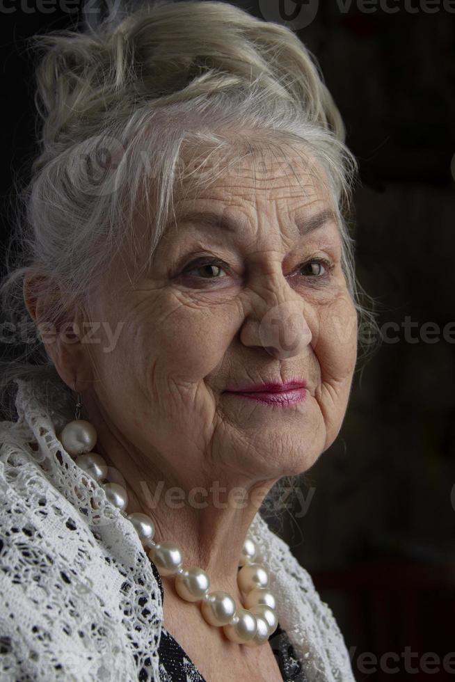 retrato do uma noventa ano velho mulher. lindo velho senhora. luxuoso avó em uma Preto fundo. idosos beleza. a grisalho bem cuidado pensionista. foto