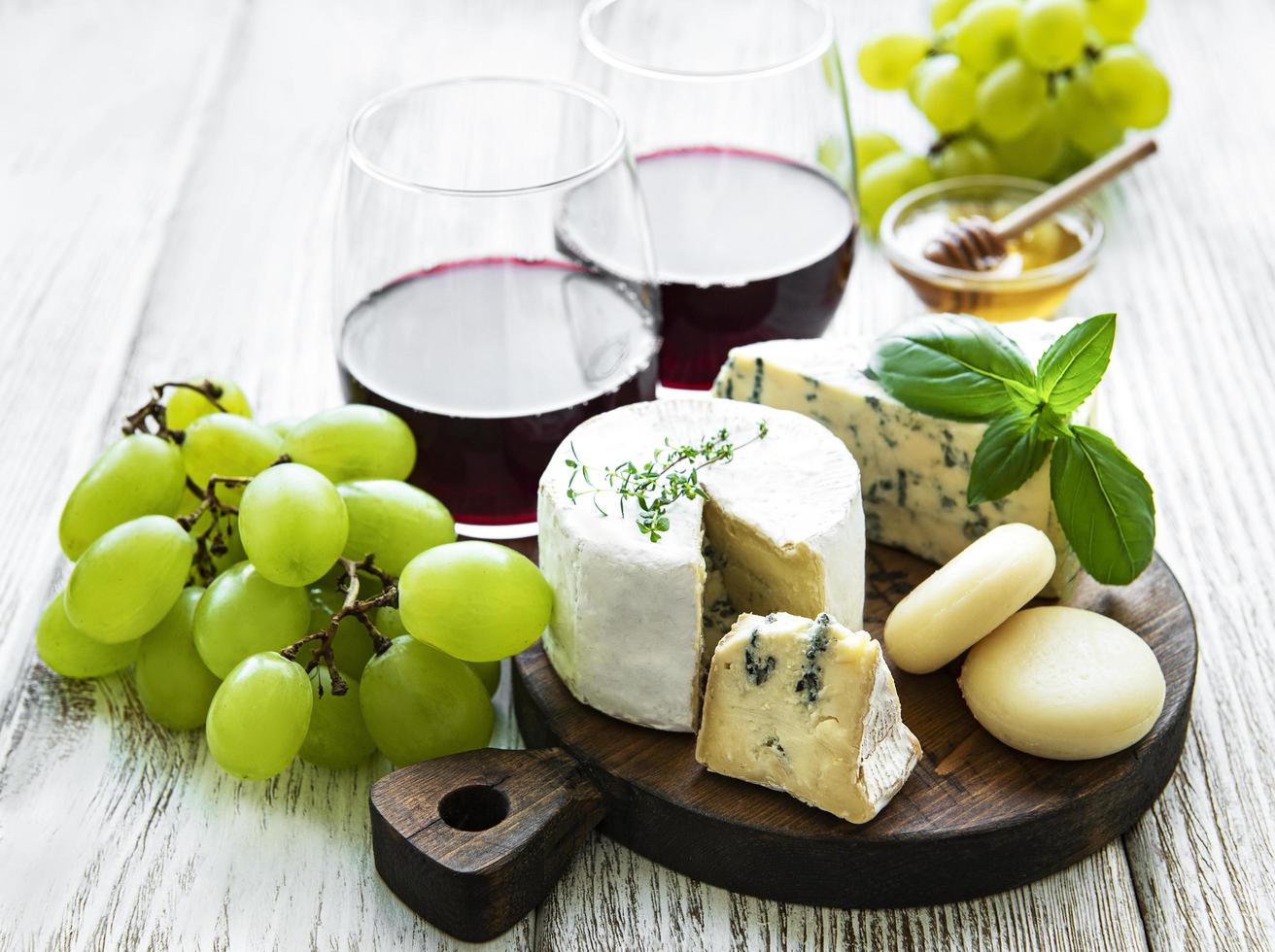 vários tipos de queijos, uvas e vinhos foto