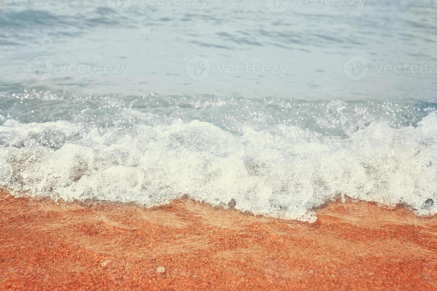 praia de areia com ondas do mar foto