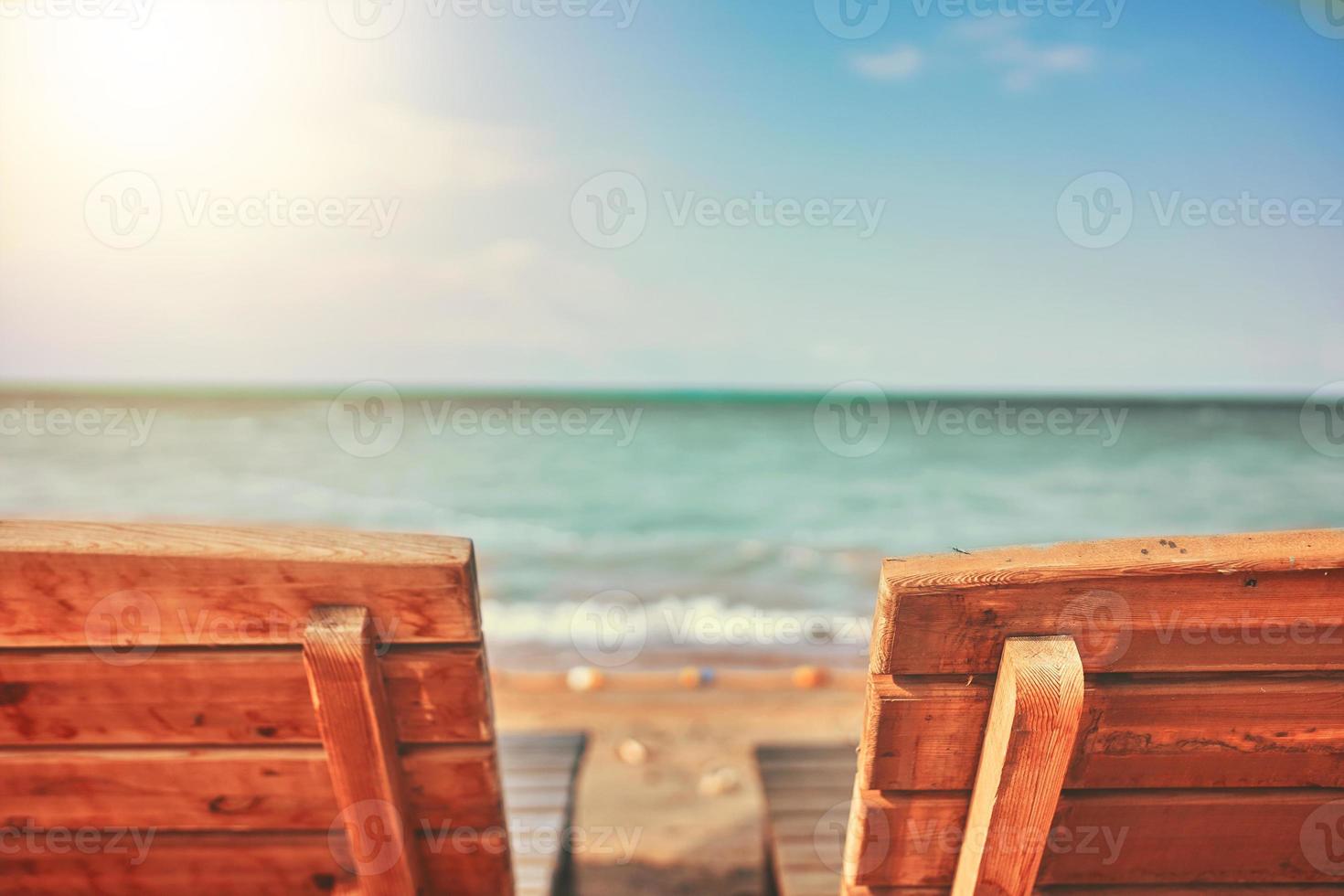 duas espreguiçadeiras de treliça de madeira na praia foto