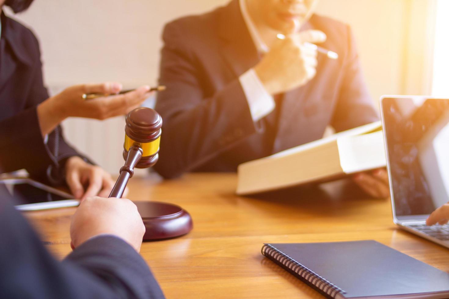 equipe do advogados tendo legal discussão segurando juízes malho dentro seus mãos para batida em a de madeira teclado. legal conselho para justiça dentro judicial procedimentos para pureza e justiça do juízes. foto