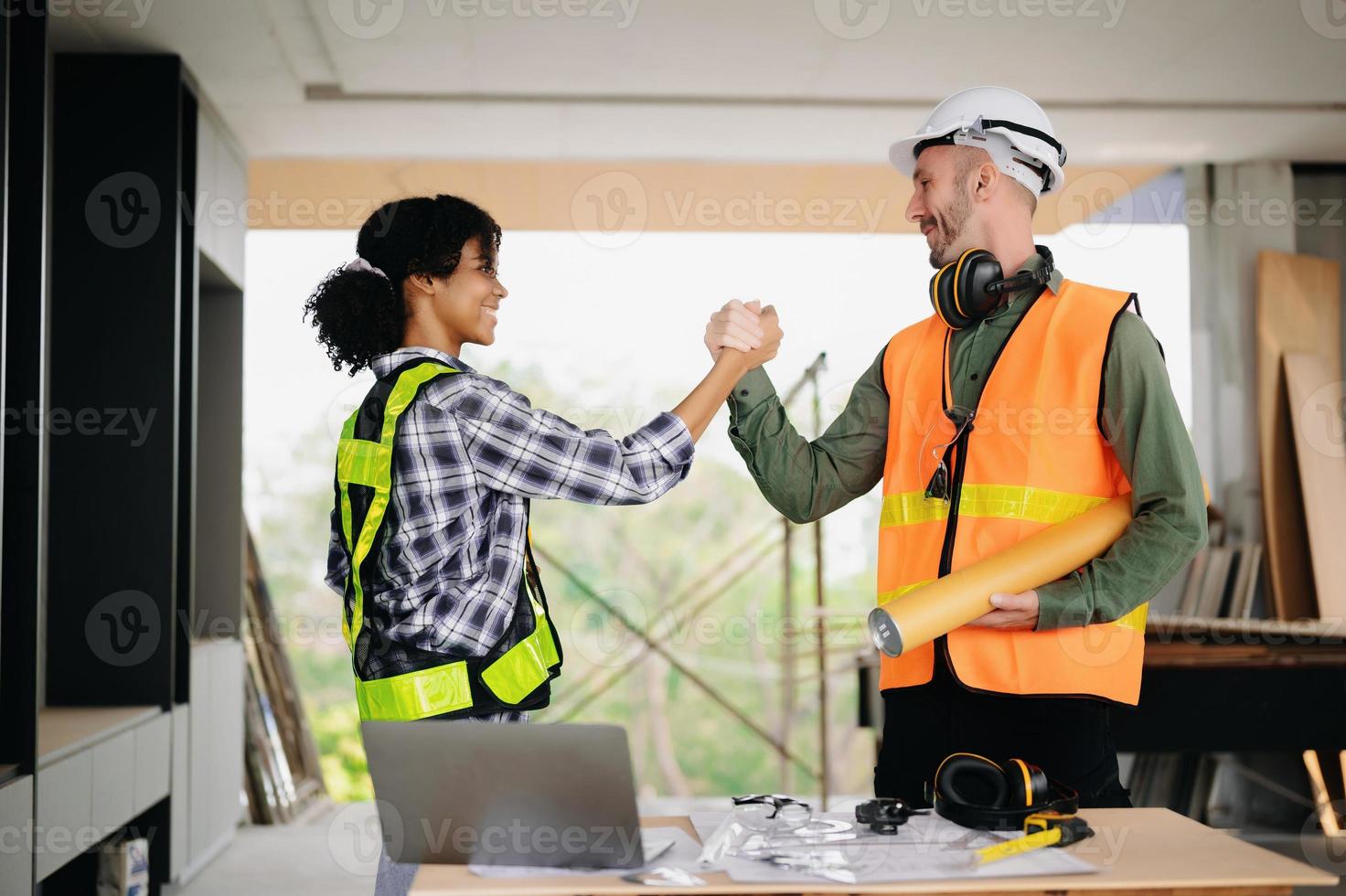 engenheiro e empreiteiro dão as mãos após a assinatura do contrato, eles estão tendo um projeto de construção moderno juntos. conceito de cooperação bem-sucedida foto