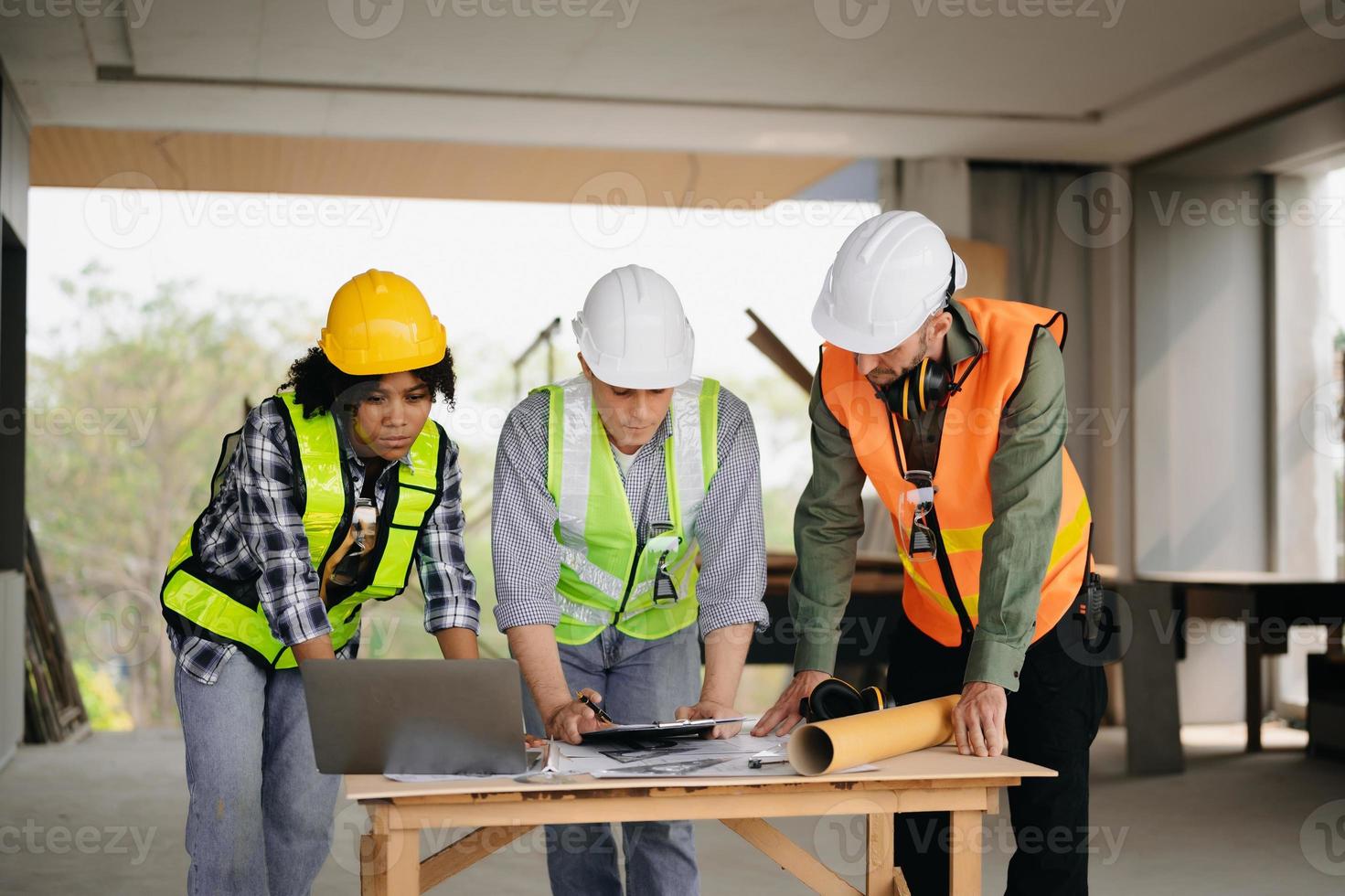 arquiteto caucasiano homem e mulher trabalhando com colegas misturado raça dentro a construção local. arquitetura Engenharia em grande projeto. construção dentro construção processo interior. foto