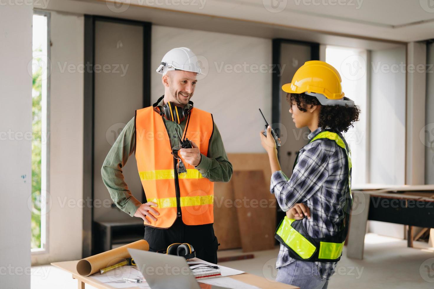 arquiteto caucasiano homem e mulher trabalhando com colegas misturado raça dentro a construção local. arquitetura Engenharia em grande projeto. construção dentro construção processo interior. foto