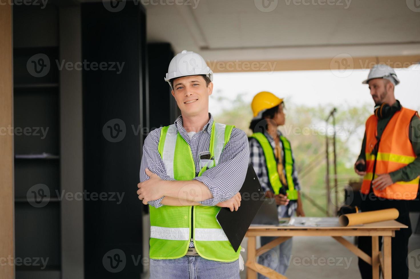 contratante e arquiteto olhando às plano, tábua, computador portátil e falando sobre trabalhando em grande projeto. construção dentro construção processo interior. equipe trabalhos foto