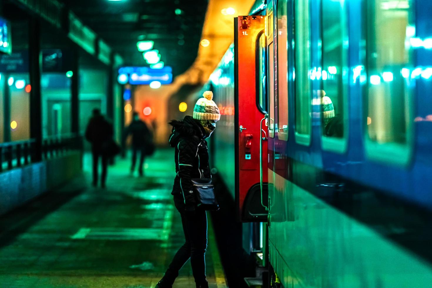 mulher embarcando em um trem noturno na estação foto