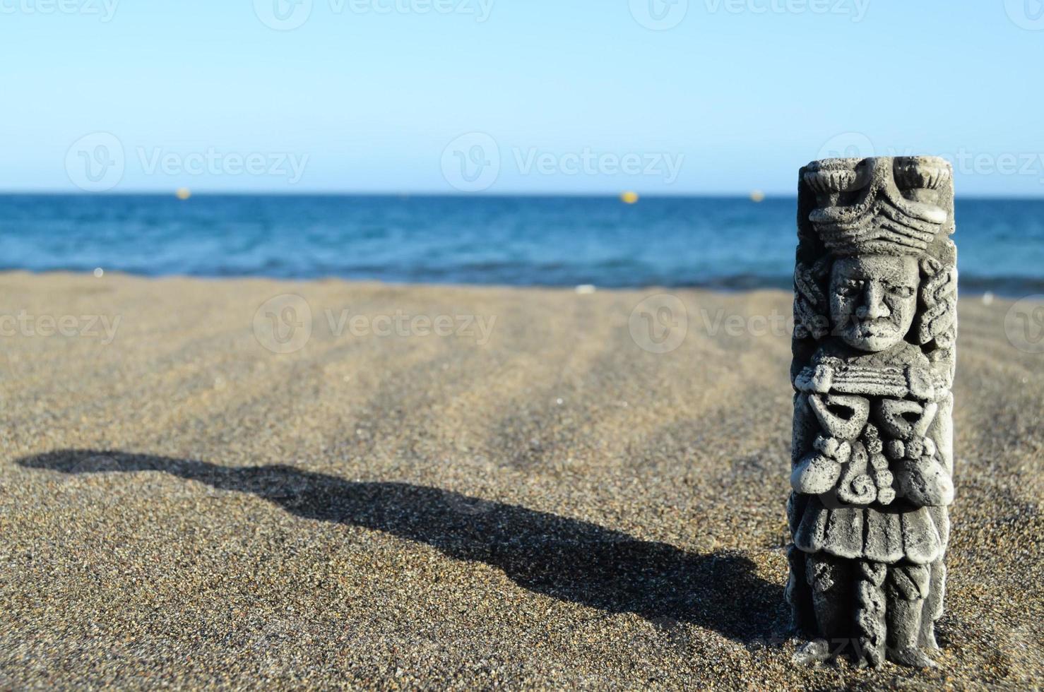 pequena estátua na areia foto