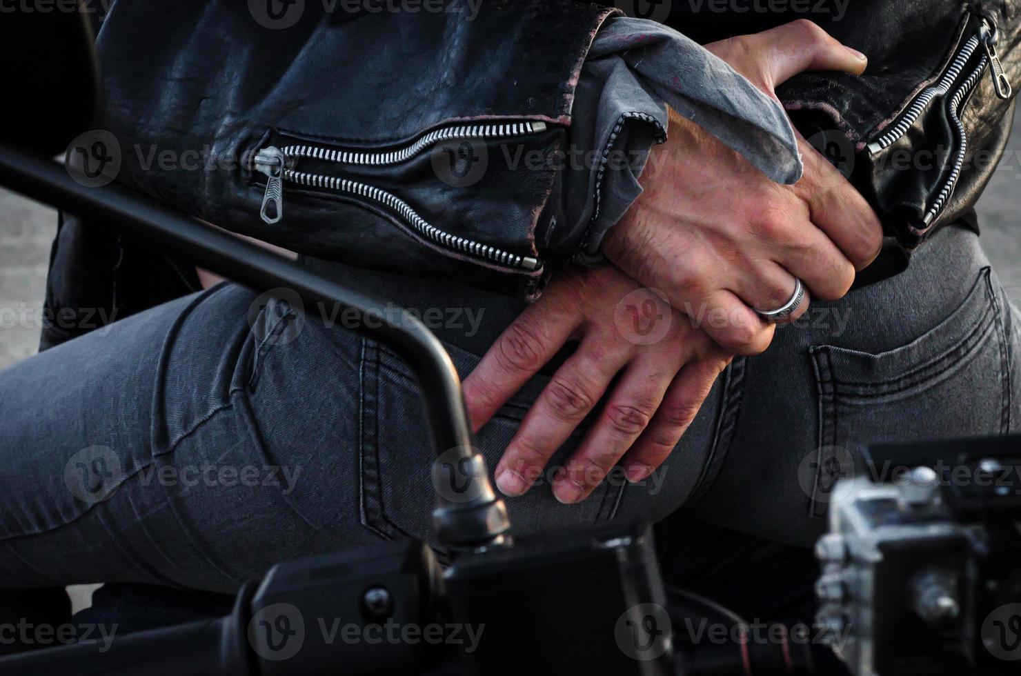 mãos de um motociclista abraçando outro motociclista em uma motocicleta foto