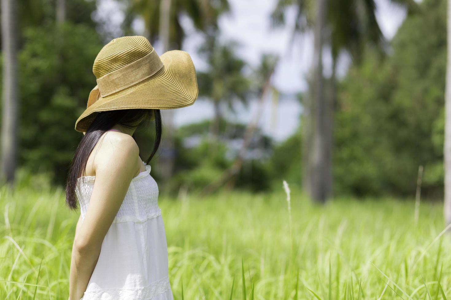 mulher usando um vestido branco em pé no jardim foto