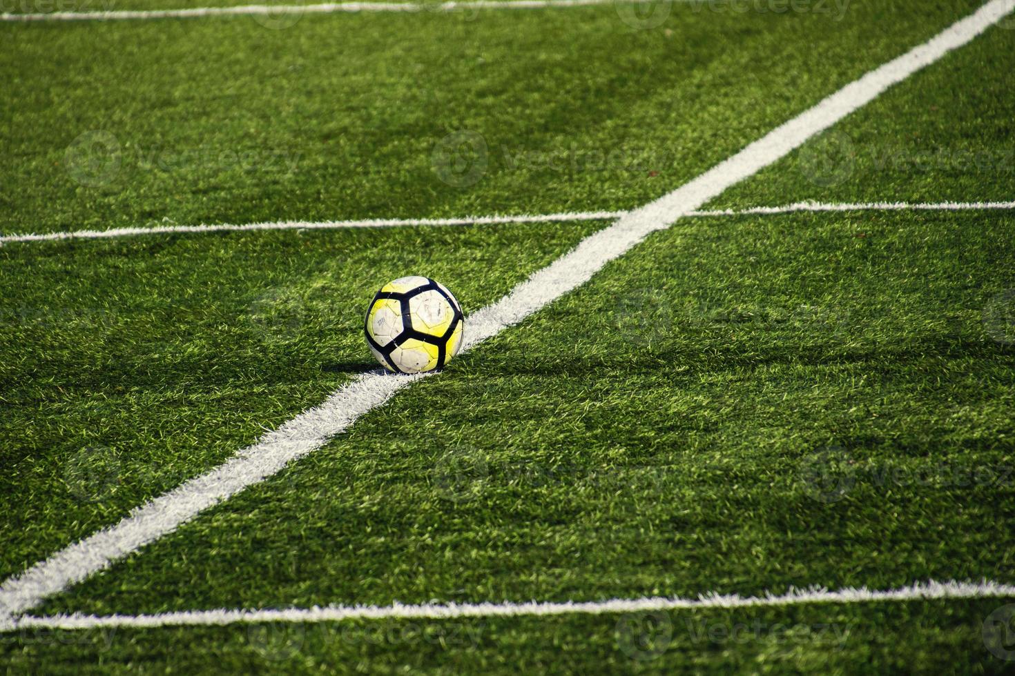 futebol deitado em uma verde campo com artificial território em uma lindo dia foto