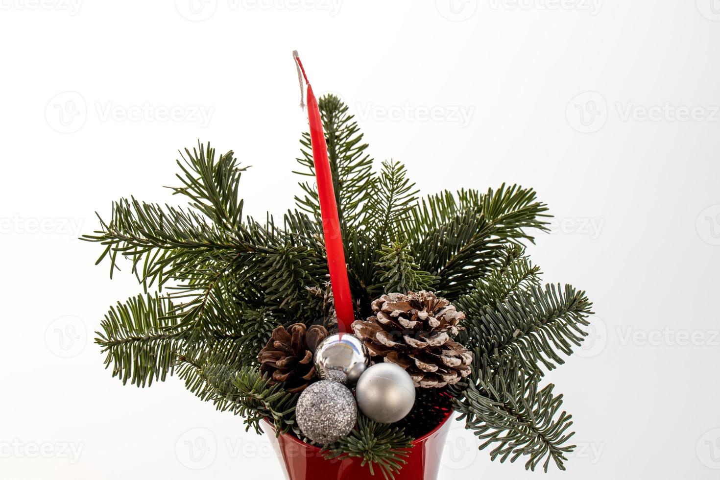 enfeite do uma Natal árvore dentro uma vermelho Panela com uma vela em uma branco fundo foto