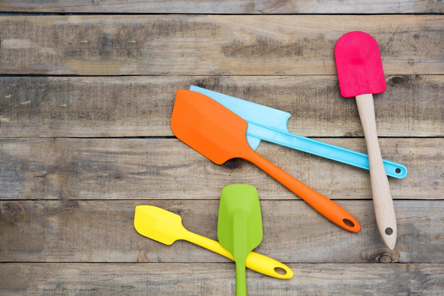 Padaria de silicone e utensílios de cozinha em uma mesa de madeira foto