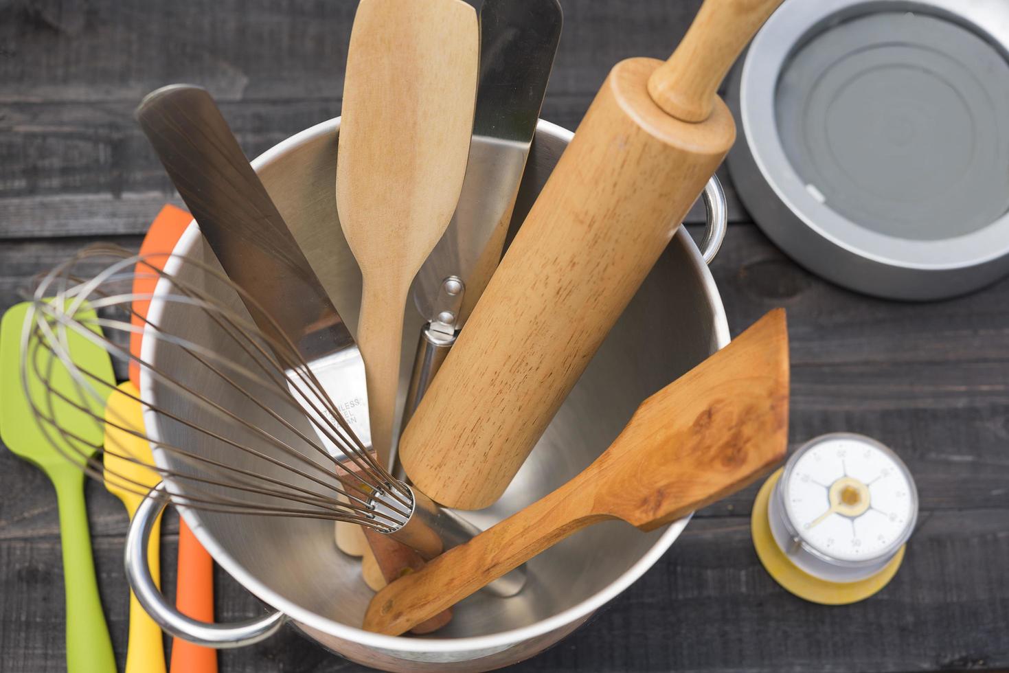 Panificação e utensílios de cozinha com cronômetro de cozinha em uma mesa de madeira foto