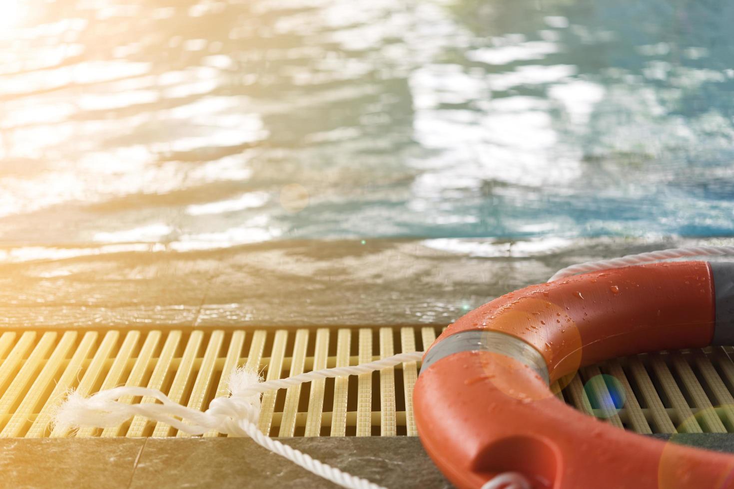 dispositivo de flutuação laranja ao lado de uma piscina foto