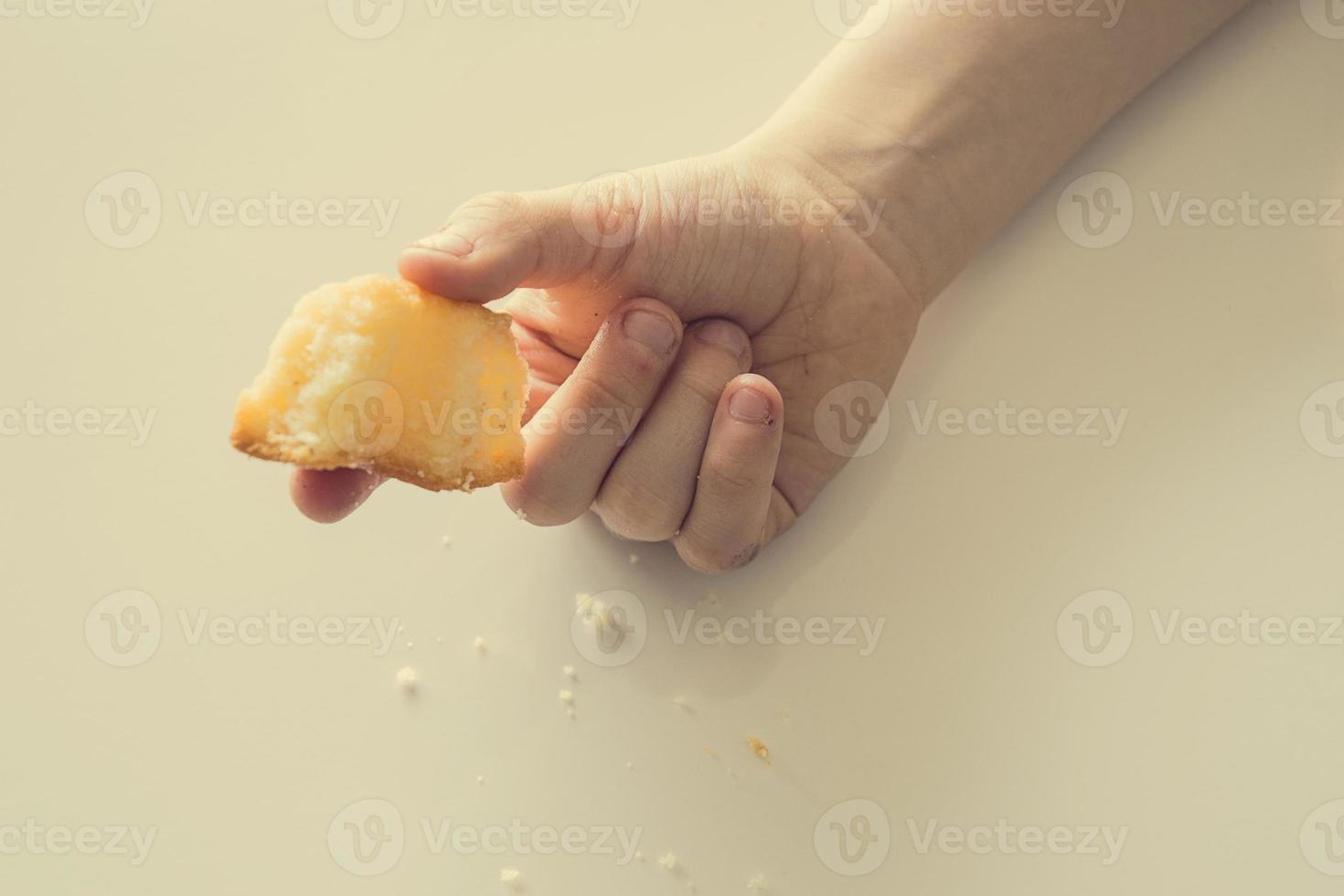 saboroso pequeno Páscoa Bolinho em uma criança mão em uma luz fundo foto