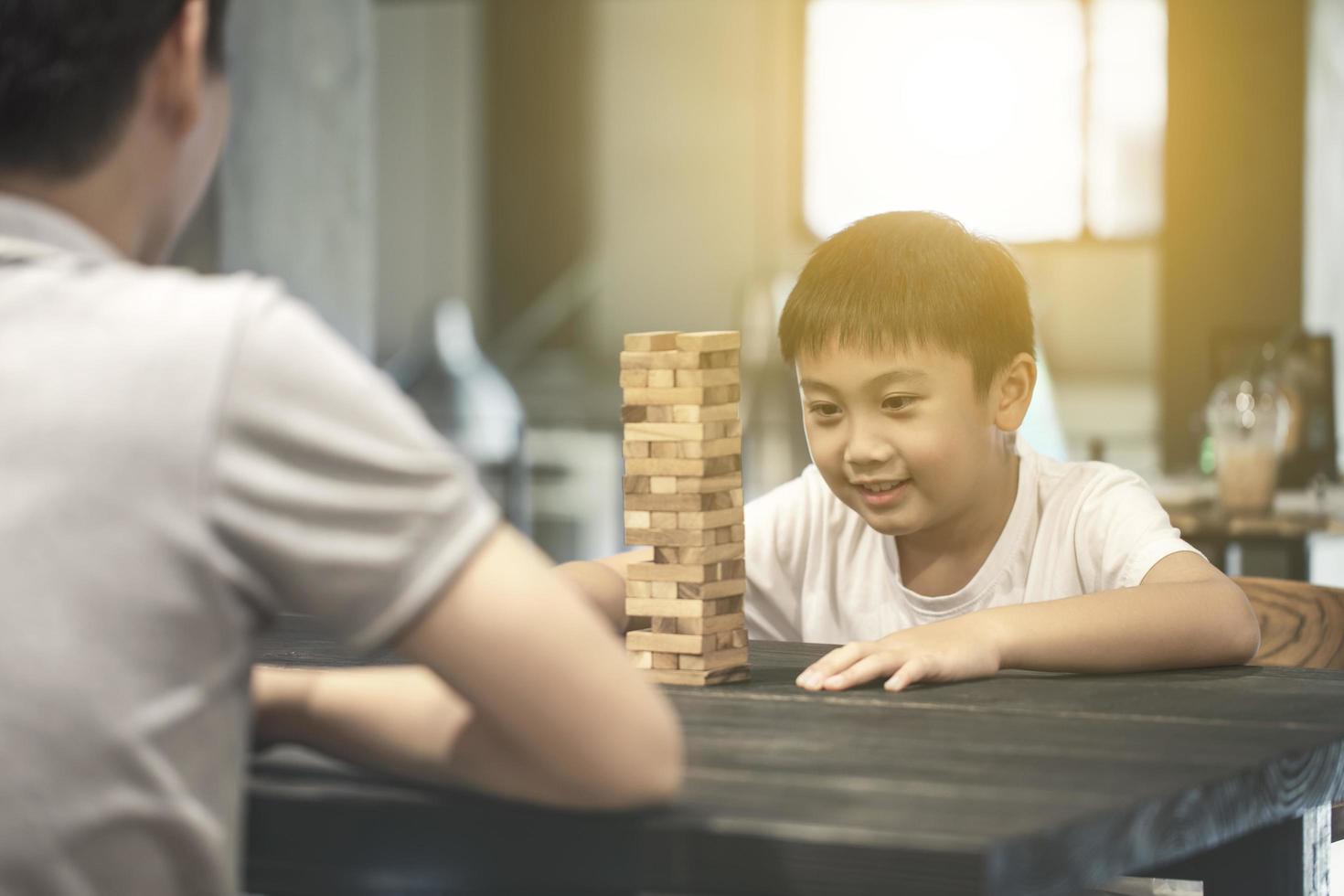 pai e filho jogando jogo de blocos de madeira foto